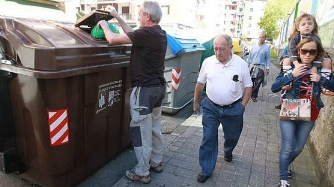 Un vecino usa el contenedor de residuos orgánicos.  ARCHIVO EFE