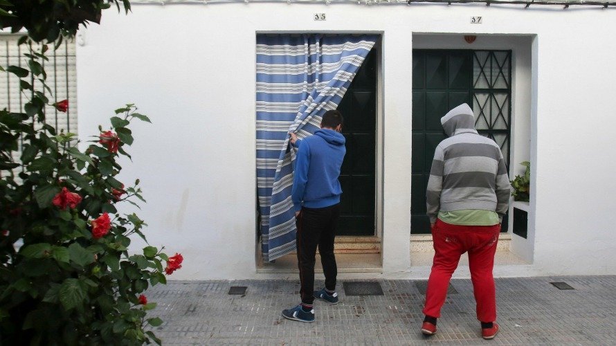 Dos vecinos de Sanlúcar La Mayor observan la sangre en la entrada de la vivienda donde un hombre ha matado a su mujer. EFE, Julio Muñoz.