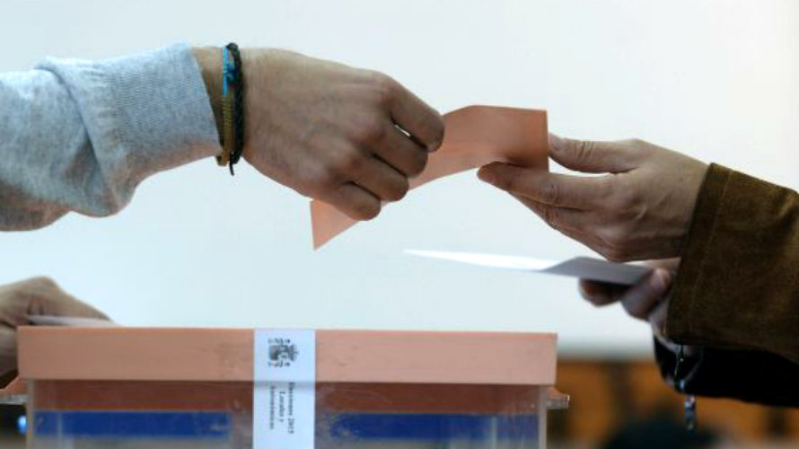 Una mujer entrega sus sobres en una mesa electoral. EFE