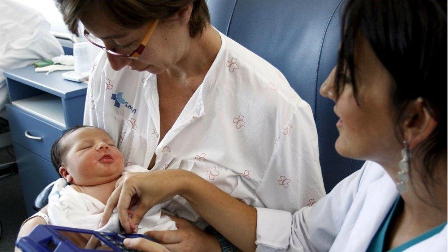Una matrona toma la huella dactilar de un recién nacido en un hospital de Ávila. EFE.