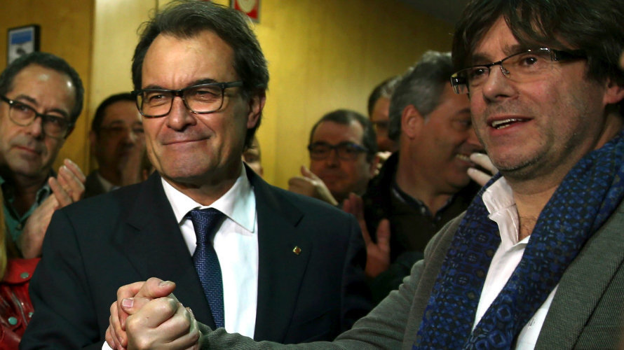 El presidente catalán en funciones, Artur Mas (i), estrecha la mano del alcalde de Girona, Carles Puigdemont (d), a su llegada a la sede de CDC
