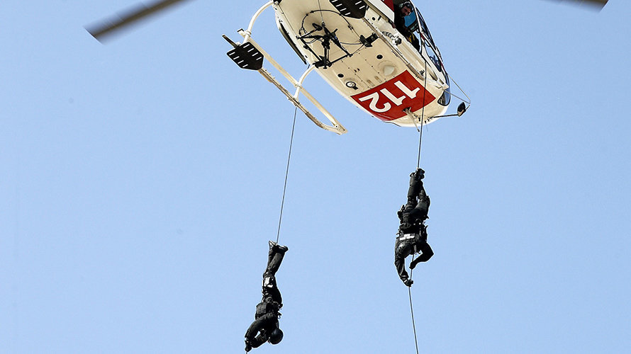 Dos miembros del Grupo de Intervención Especial de la Policía Foral rapelan desde un helicoptero durante un simulacro. EFE/Jesús Diges
