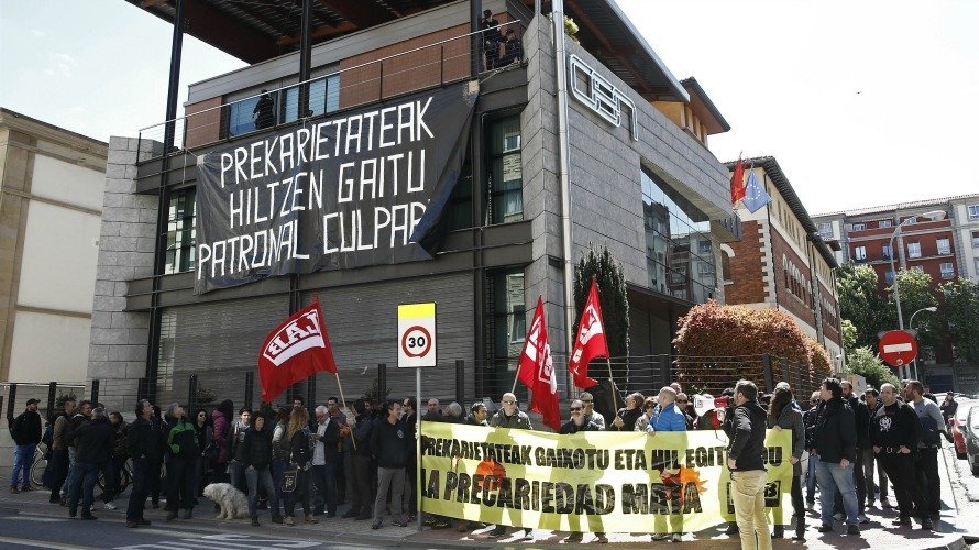 Miembros del sindicato LAB han cubierto la fachada de la sede de la CEN con una gran pancarta negra. EFE. JESÚS DIGES