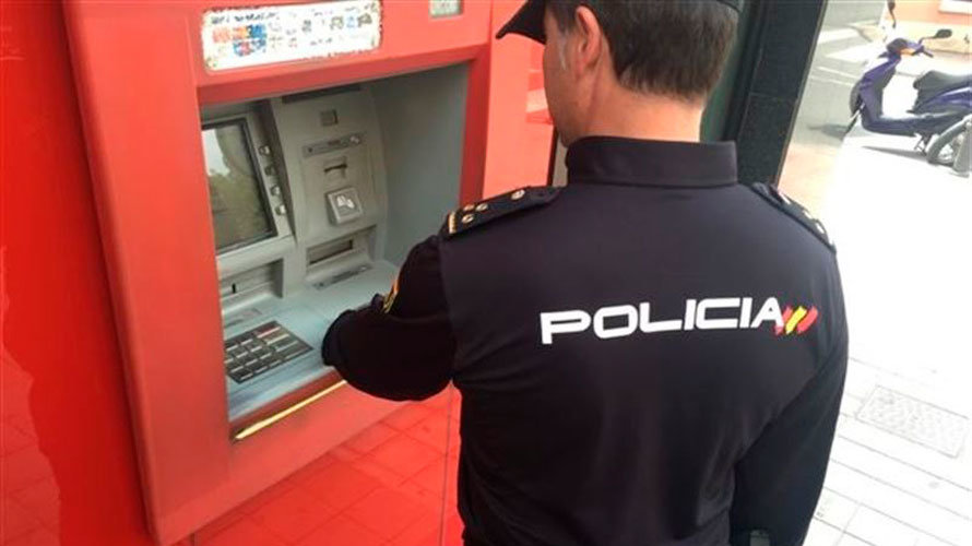 Un policía nacional revisa un cajero automático