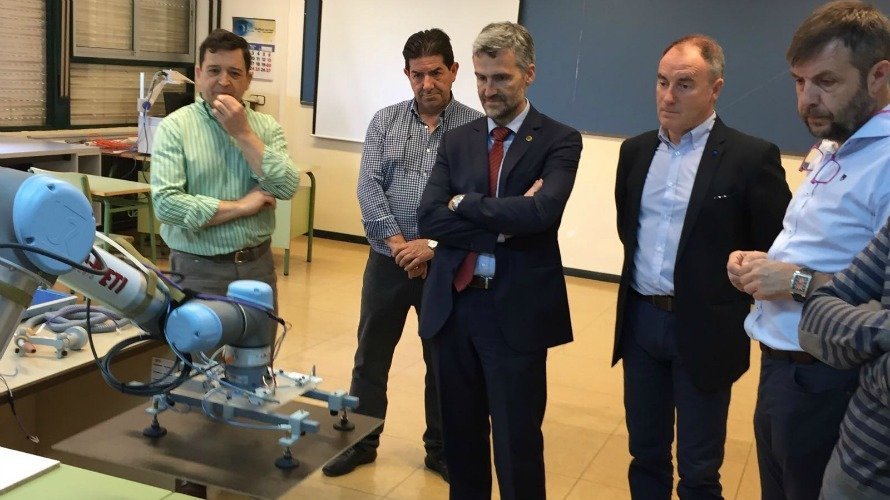 Alfonso Carlosena, en el centro, observa el trabajo de un robot utilizado en el centro ETI junto a Juan Carlos Ciria, a su izquierda, y a un grupo de profesores.
