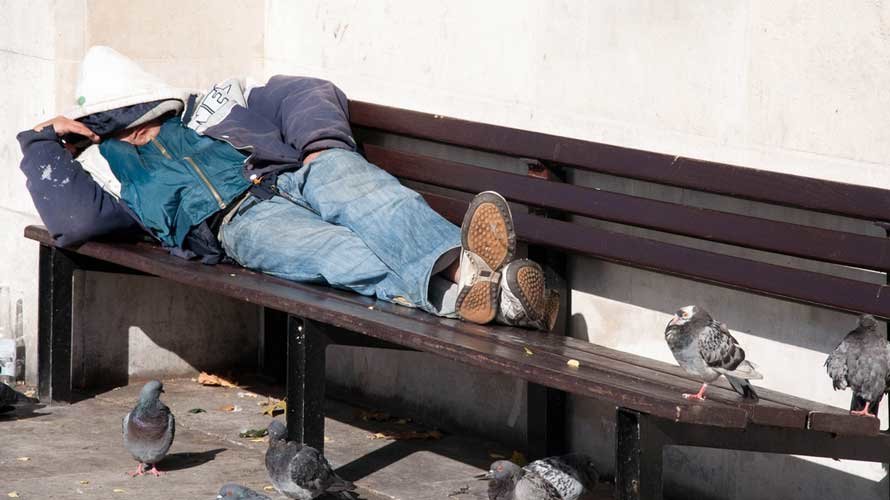 Imagen de un mendigo durmiendo en la calle.