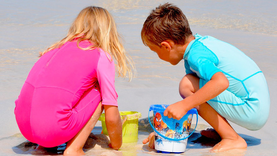 Niños jugando con la arena en una playa. ARCHIVO