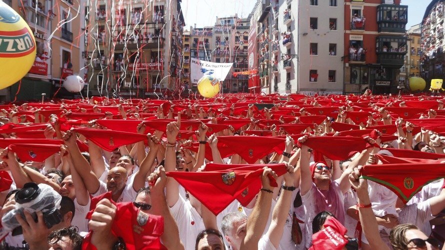 Miles de personas muestran en alto el tradicional pañuelico rojo en la Plaza del Ayuntamiento de Pamplona durante el lanzamiento del Chupinazo. EFE. JAVIER LIZÓN (4)