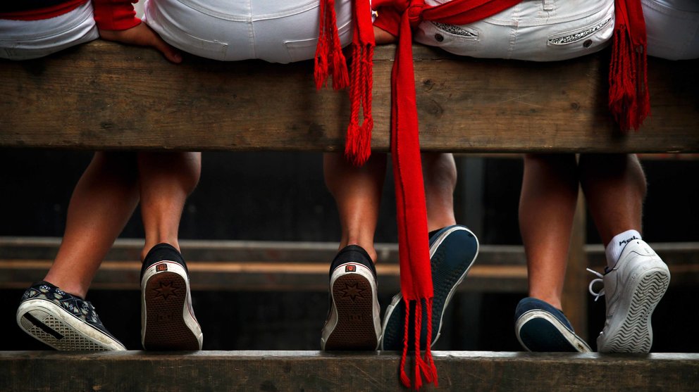 Revellers sit on the bull run fence as they wait for the start of the fifth running of the bulls at the San Fermin festival in Pamplona, northern Spain, July 11, 2016. REUTERS/Susana VeraCODE: X01622