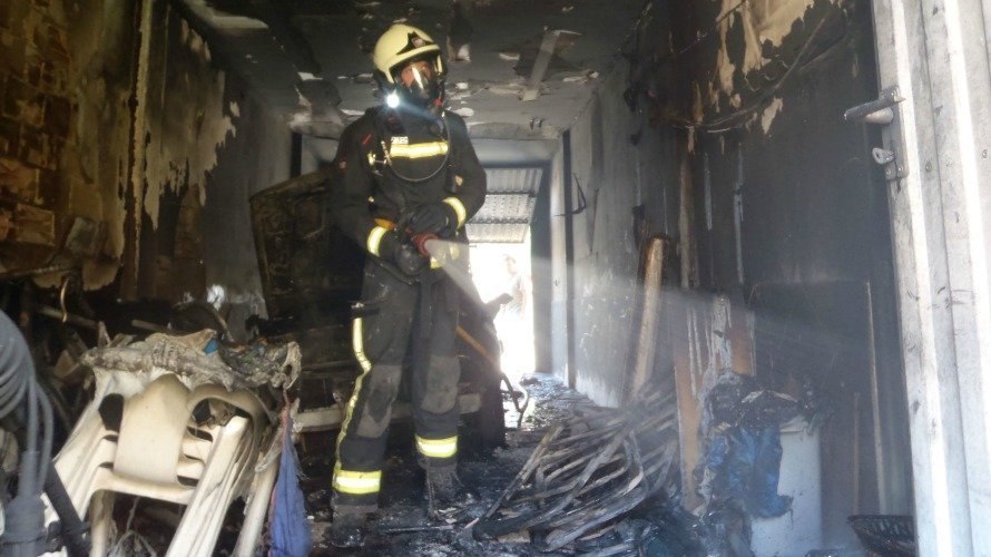 Un bombero inspecciona el garaje incendiado en Cintruénigo. PFORAL