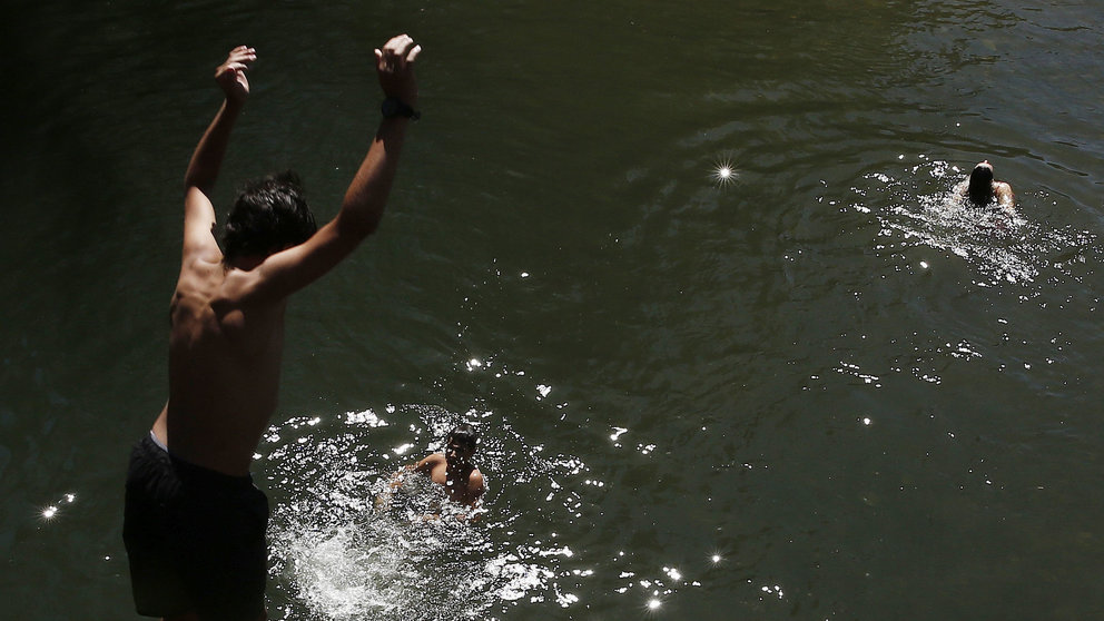 Un grupo de jóvenes se bañan en el rio Arga. Las imágenes del tiempo marcado por el calor vivido en Pamplona. EFE/Jesús Diges