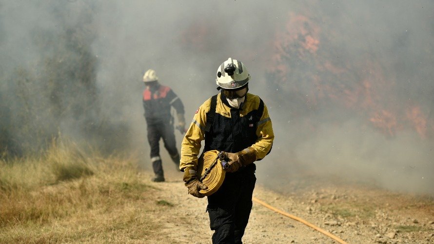 Bomberos trabajando en las labores de extinción del incendio de Tafalla. PABLO LASAOSA