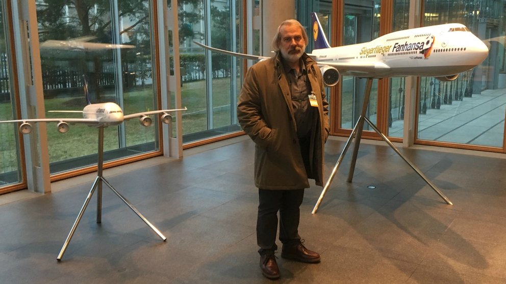 El escultor navarro  Carlos Ciriza posa con dos maquetas de los aviones de la compañía   Lufthansa.