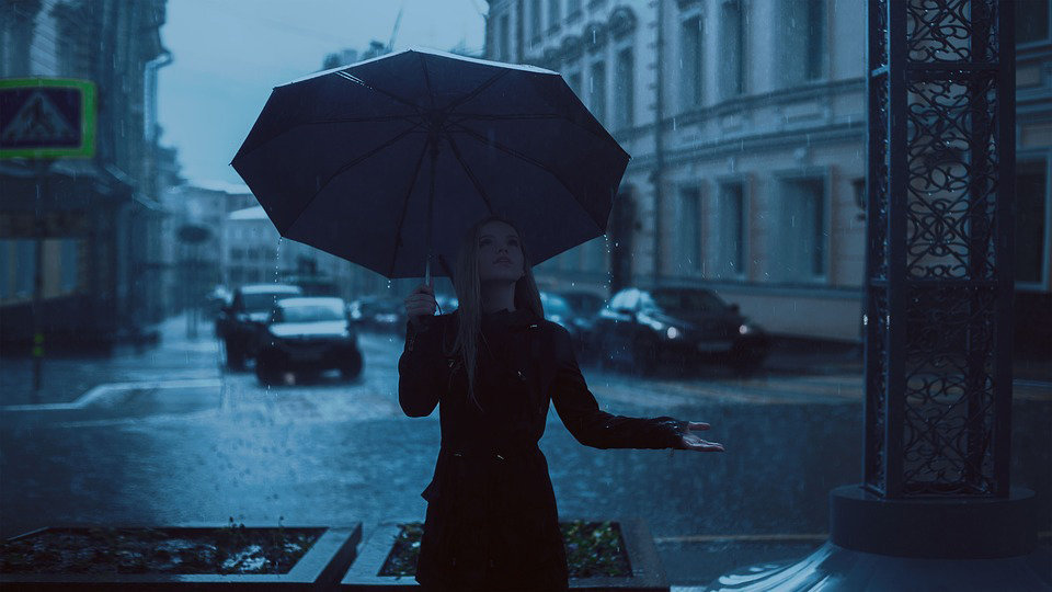 Imagen de una chica bajo su paraguas durante una jornada de tiempo lluvioso.