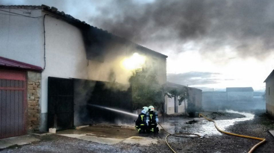 Los bomberos trabajan en la extinción del incendio de una vivienda en Traibuenas