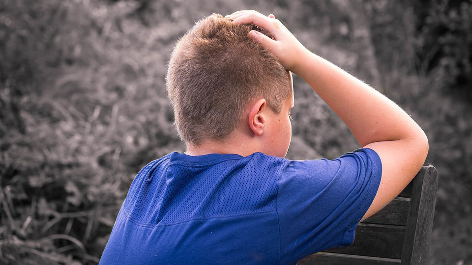 Un niño, víctima de bullying, se lleva las manos a la cabeza en gesto de desesperación. ARCHIVO