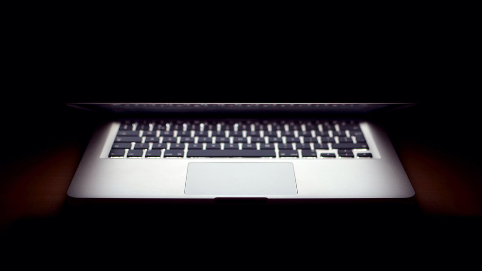 Un ordenador macbook sobre un escritorio de trabajo.