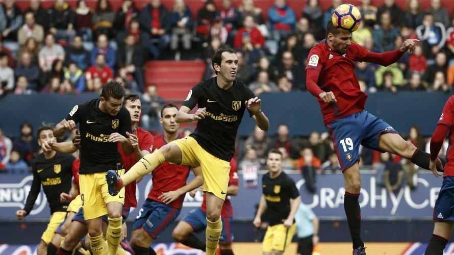 El delantero del Osasuna Kenan Kodro (d) cabecea el esférico ante el defensa uruguayo del del Atlético de Madrid Diego Godin. EFEJesús Diges