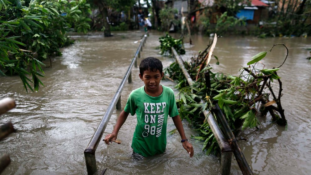 Un adolescente cubre una zona inundada por el paso del tifón Nock-Ten por la localidad de Pamplona, Camarines Sur (Filipinas), el 26 de diciembre de 2016, al menos tres personas han muerto. EFE/Francis R. Malasig