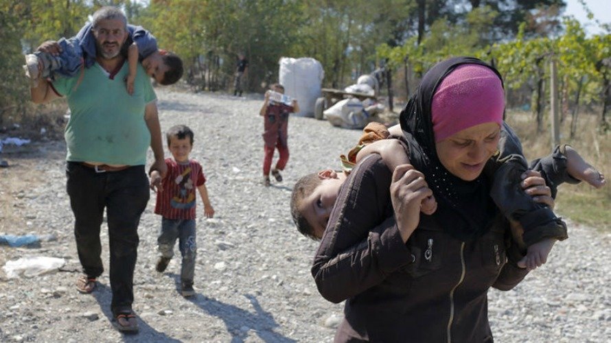 Refugiados cruzan la frontera entre Macedonia y Grecia.  EFE