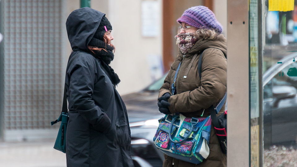 Dos mujeres hablan junto a una marquesina en el Paseo Sarasate de Pamplona a temperatura bajo cero (1). IÑIGO ALZUGARAY