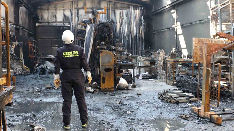 Especialistas en incendios pertenecientes a la Unidad Orgánica de Policía Judicial de la Guardia Civil de Navarra inspeccionan una nave incendiada en el polígono de Beriáin 2