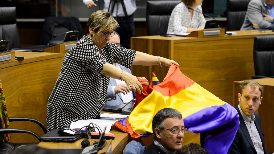 Marisa de Simón coloca la bandera republicana en el Parlamento de Navarra. PABLO LASAOSA