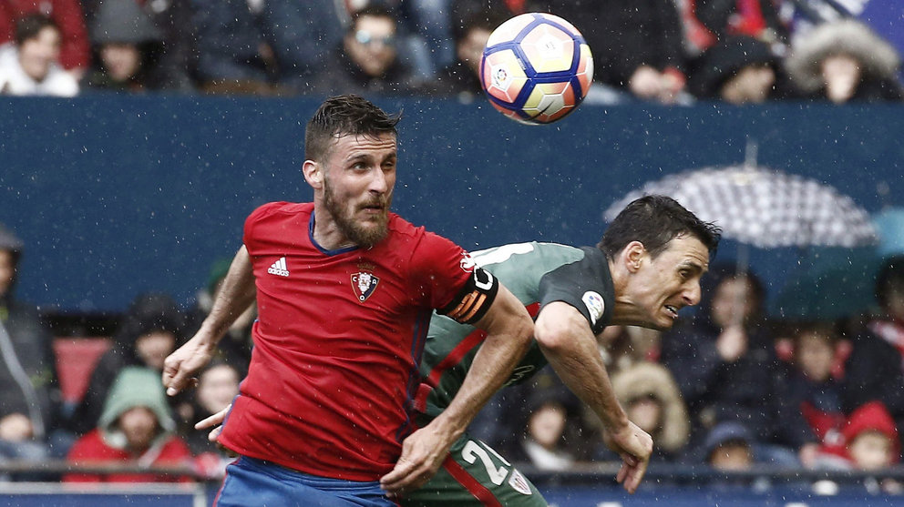 El defensa de Osasuna Oier Sanjurjo (i) disputa un balón con el delantero del Athletic de Bilbao Aritz Aduriz (d) durante el partido correspondiente a la vigésimo novena jornada de LaLiga Santander disputado hoy en el estadio El Sadar. EFE/Diges