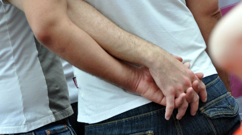 Gay Couple Holds Hands behind back