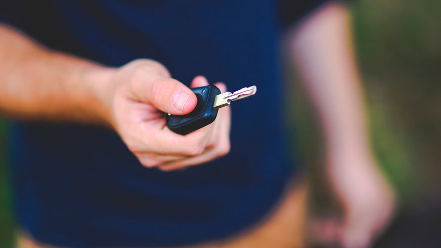 Una persona entrega las llaves de su coche a otra. ARCHIVO.