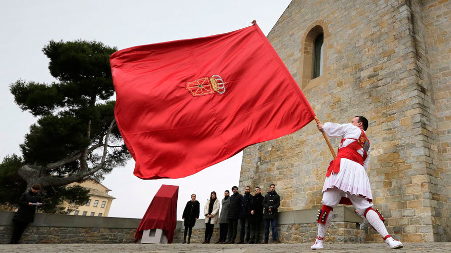 La presidenta Barkos y otros cargos políticos de Navarra contemplan la bandera foral ondear en un acto.