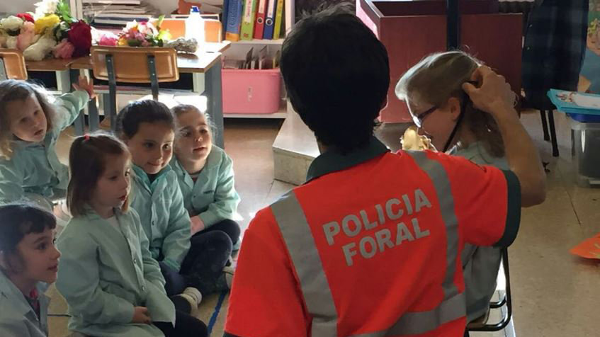 Un agente de la Policía Foral imparte una clase de seguridad vial a varios niños en un colegio navarro POLICÍA FORAL