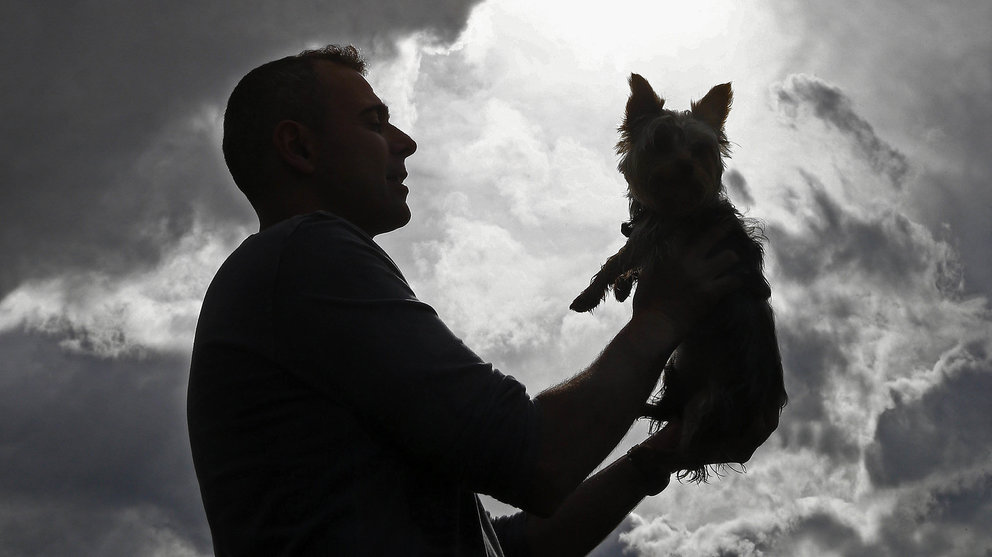 Una persona juega con su perro bajo un manto de nubes que cubren la comarca de Pamplona. EFE/Jesus Diges