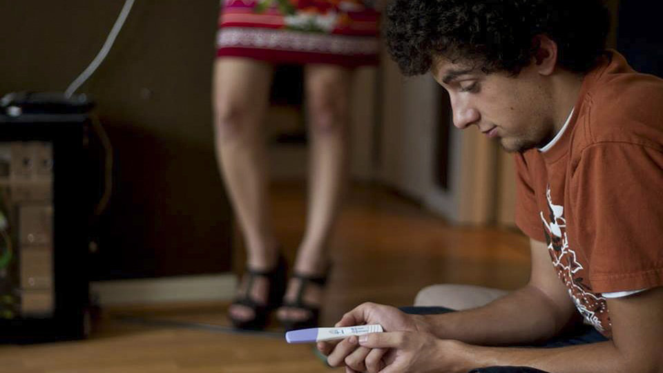 Un chico observa el test de embarazo de su pareja que confirma que serán padres ARCHIVO
