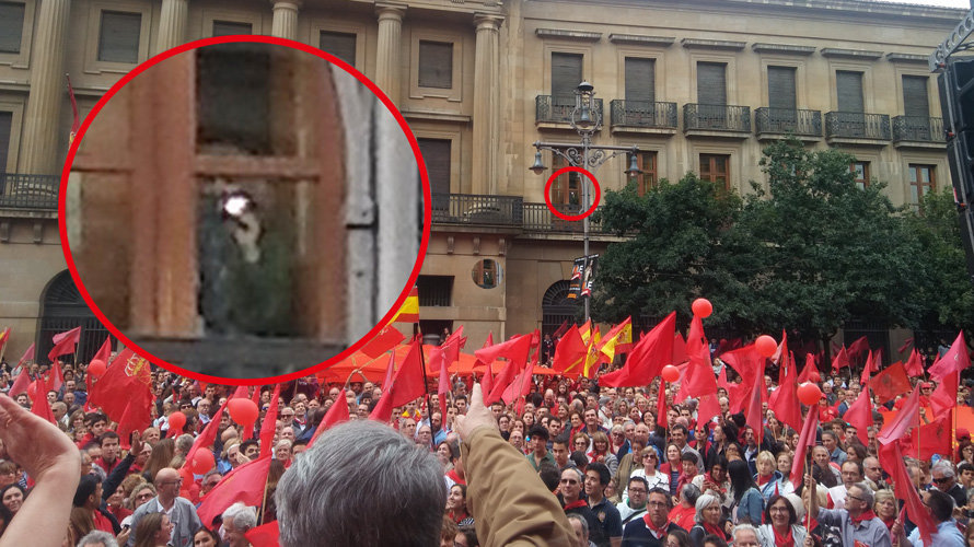 Una mujer graba desde una ventana del Palacio de Navarra la manifestación en defensa de la bandera de Navarra. NAVARRA.COM