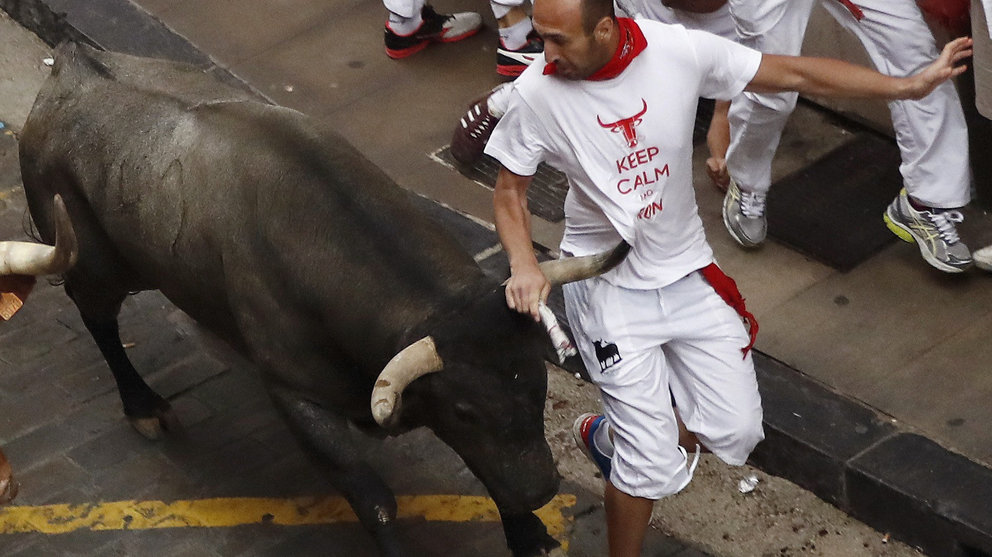Un toro de la ganadería abulense de José Escolar pone en apuros a un corredor en la Cuesta de Santo Domingo, durante el segundo encierro de los Sanfermines 2017, en el que cinco corredores han resultado heridos, dos por asta de toro. EFE/Villar López