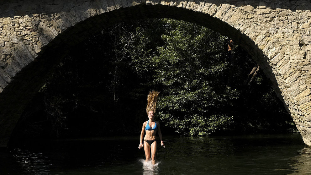 Una joven salta desde un puente al río de Irotz, localidad cercana a Pamplona, para hacer frente a las altas temperaturas que se han dado estos últimos días en Navarra. EFE/Iván Aguinaga