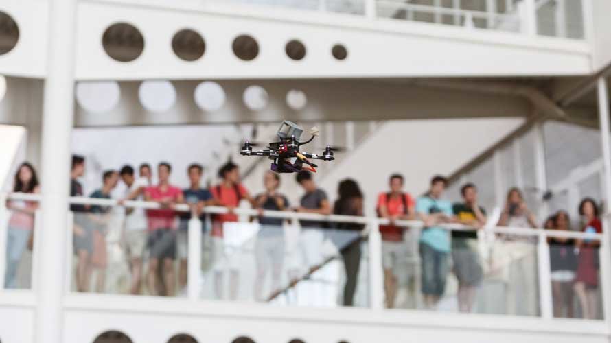 El dron, volando en el interior de la Biblioteca ante del alumnado del curso de verano. UPNA
