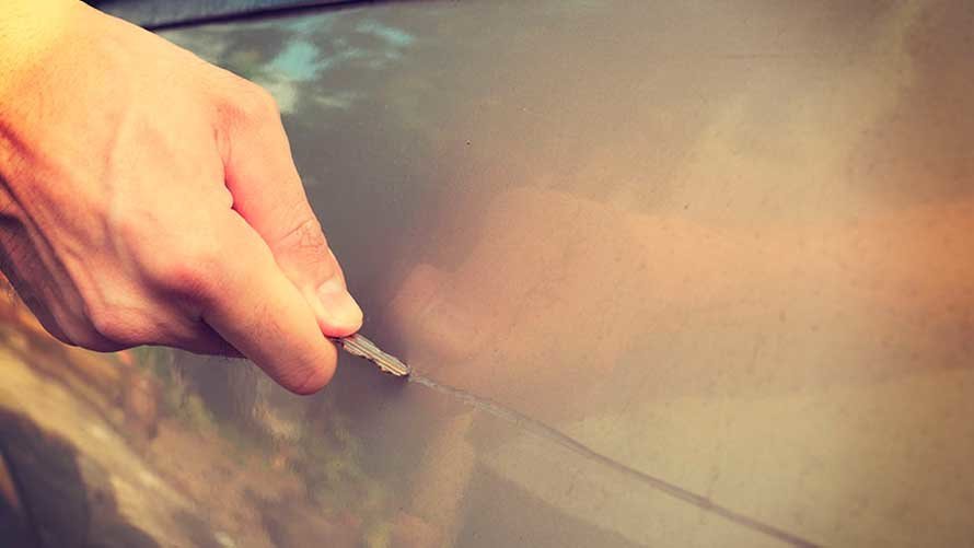 Imagen de archivo de un hombre rayando un coche con una llave. ARCHIVO