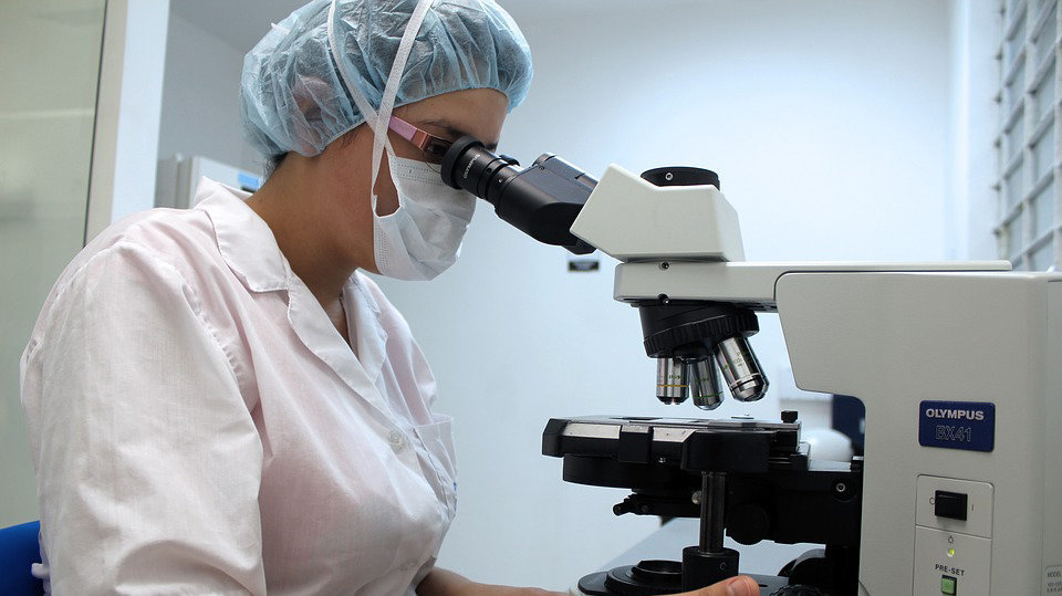 Un biólogo observa por un microscopio en el laboratorio de un hospital ARCHIVO