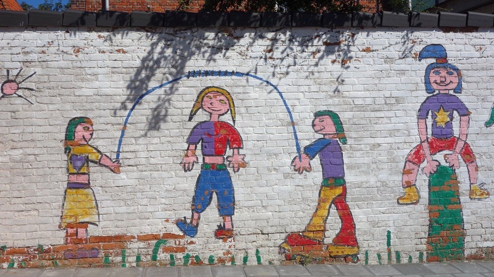 Un dibujo sobre una pared de niños jugando.