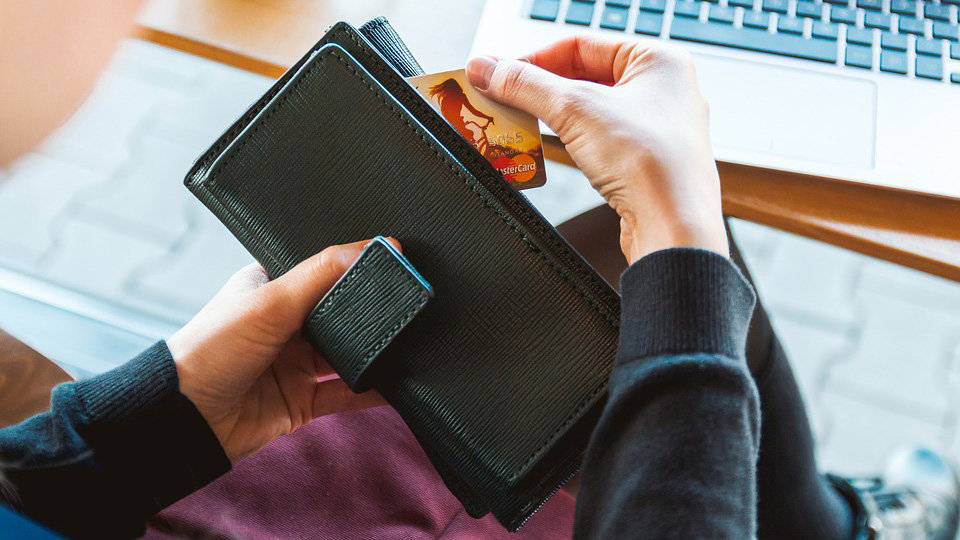 Una persona sostiene una cartera con una tarjeta de crédito ARCHIVO