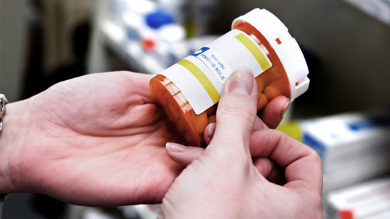 Un trabajador de un hospital sostiene un bote de medicamentos ARCHIVO