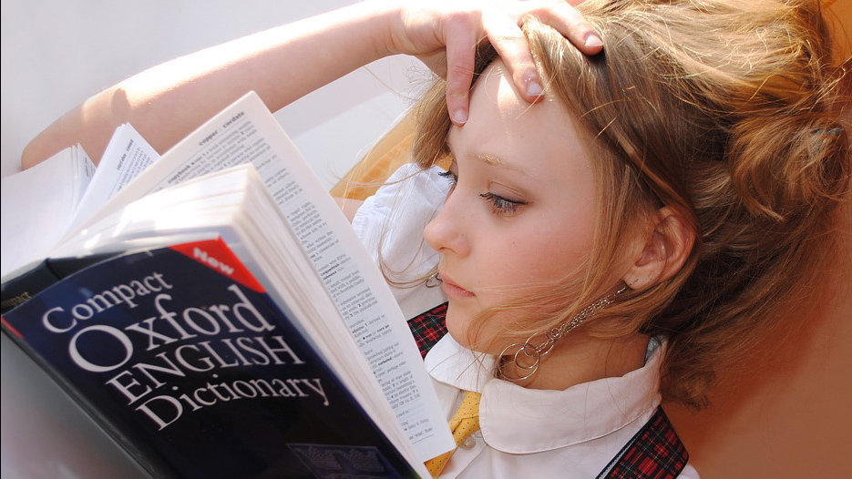 Una niña consultando términos en un diccionario de inglés