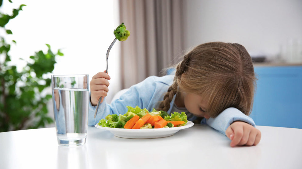 Una niña comiendo un plato de verdura ARCHIVO