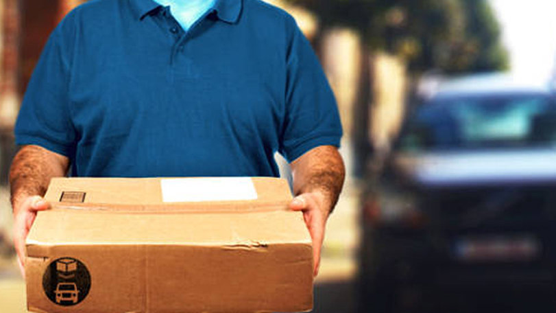 Imagen de un repartidor entregando un paquete solicitado por correo en un domicilio ARCHIVO