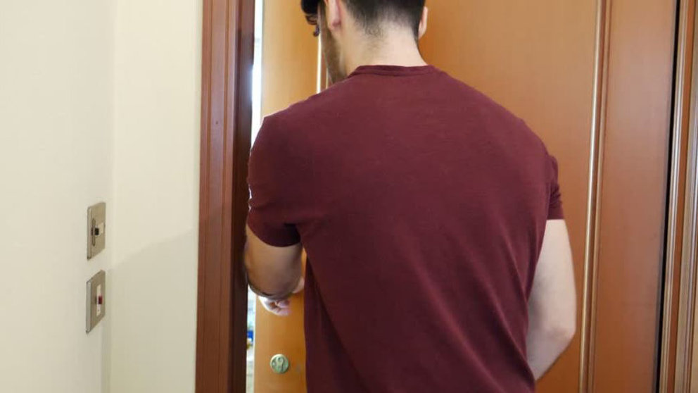 Un joven empuja la puerta de una casa