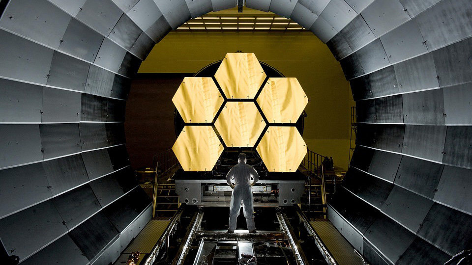 Imagen de una persona trabajando junto a varios segmentos de espejo en un innovador telescopio ARCHIVO