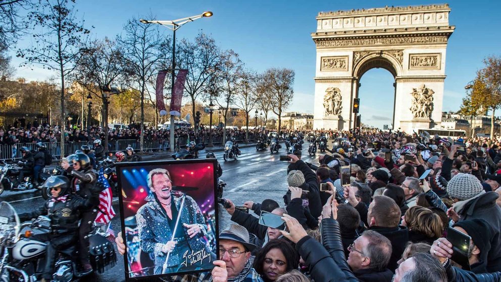 Paris (France), 09/12/2017.- A fan holds a poster of French singer Johnny Hallyday during his funeral procession at the Champs Elysees in Paris, France, 09 December 2017. Johnny Hallyday, France's biggest rock star, has died of cancer on 06 December. He was 74. (Francia) EFE/EPA/CHRISTOPHE PETIT TESSON