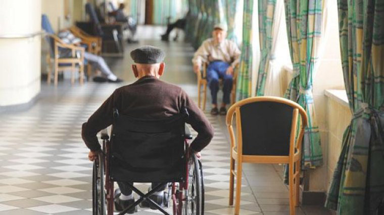 Imagen de un anciano en silla de ruedas durante su estancia en un centro de día ARCHIVO
